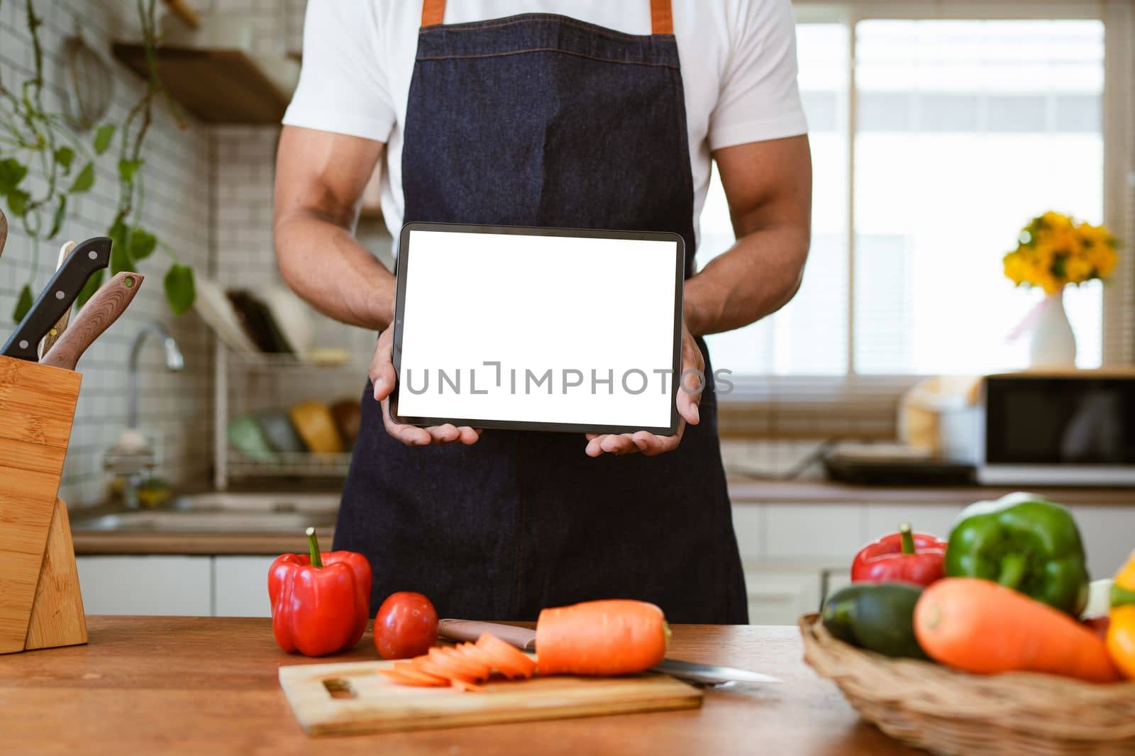 Portrait of asian man making salad and holding tablet at home. cooking food and Lifestyle moment by itchaznong