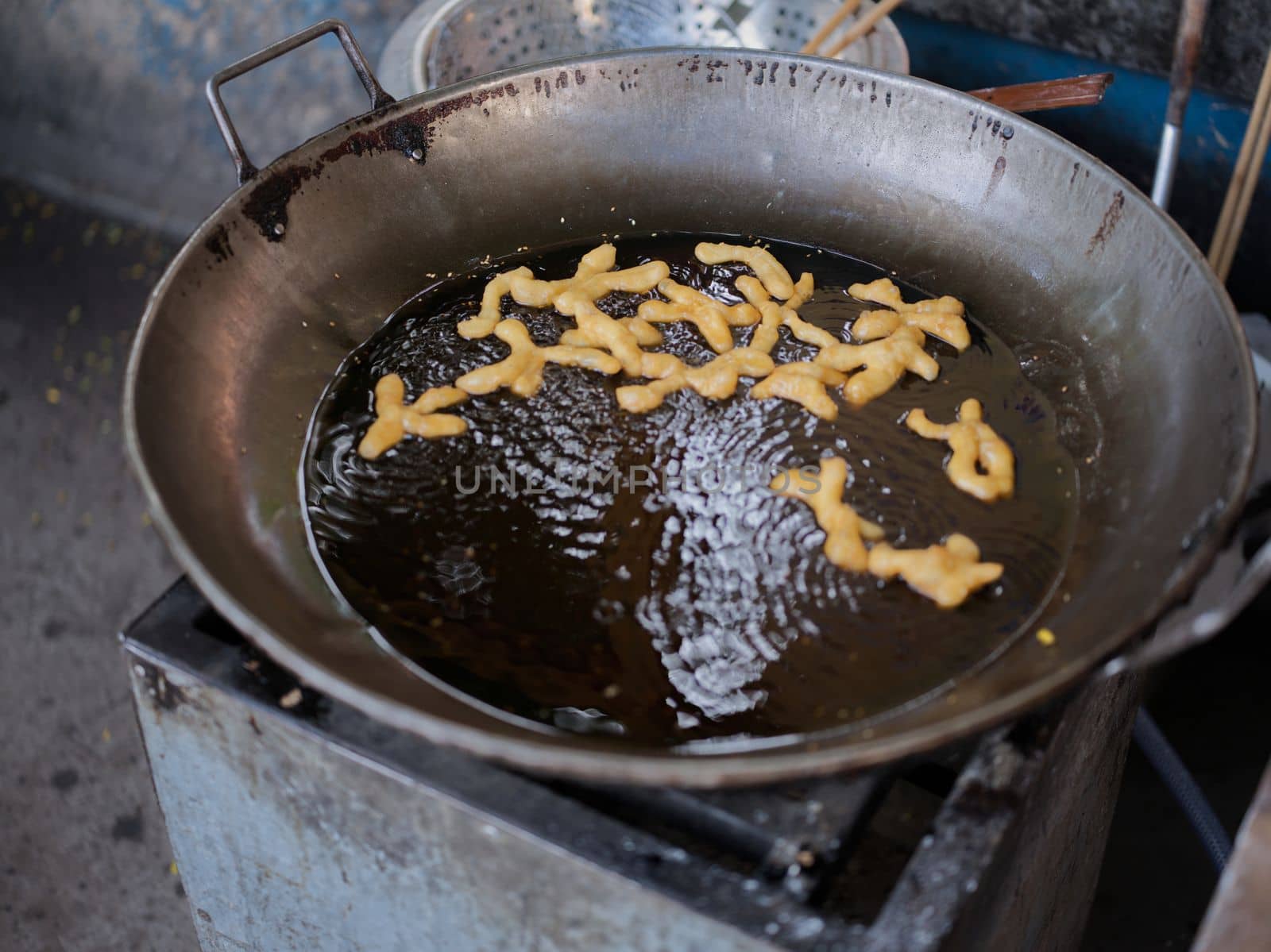 Die cut of Deep fried Chinese Doughnut in an big oil pan by Hepjam