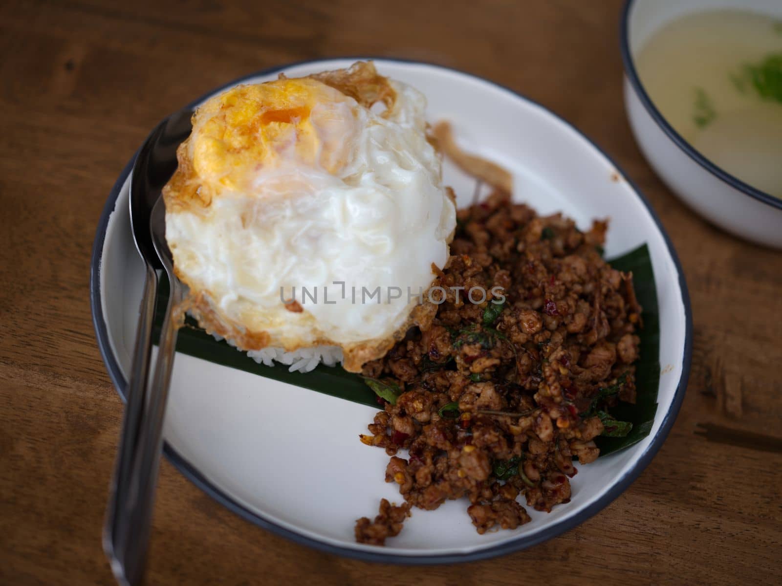 Pad Krapow MOO - Thai Basil Pork with Rice and fried Egg  background. Thai cuisine dish with minced  pork , basil, soy and oyster sauces. Thai Food Copy space by Hepjam