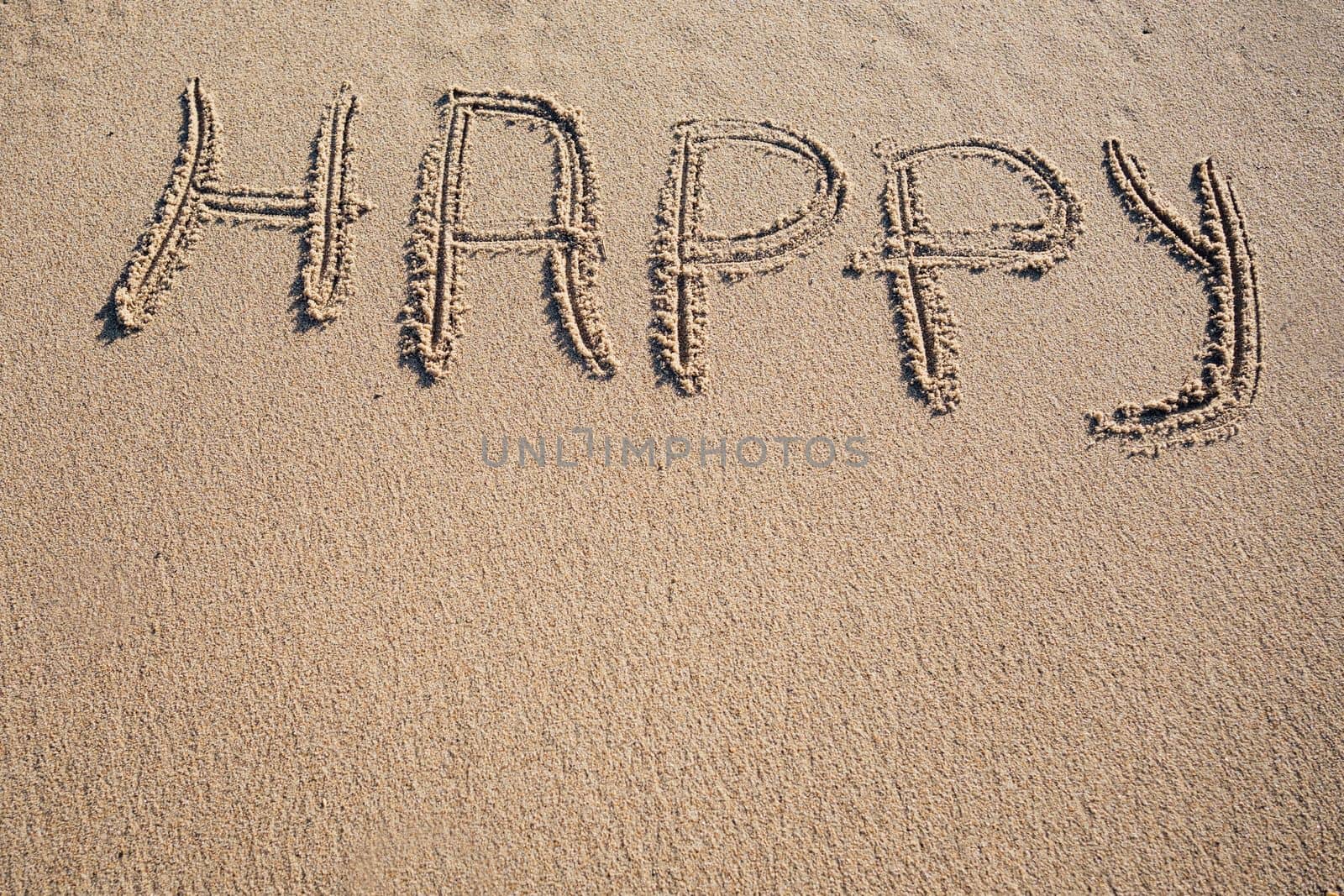 Happy word written on sand. Travel summer beach vacation concept by papatonic