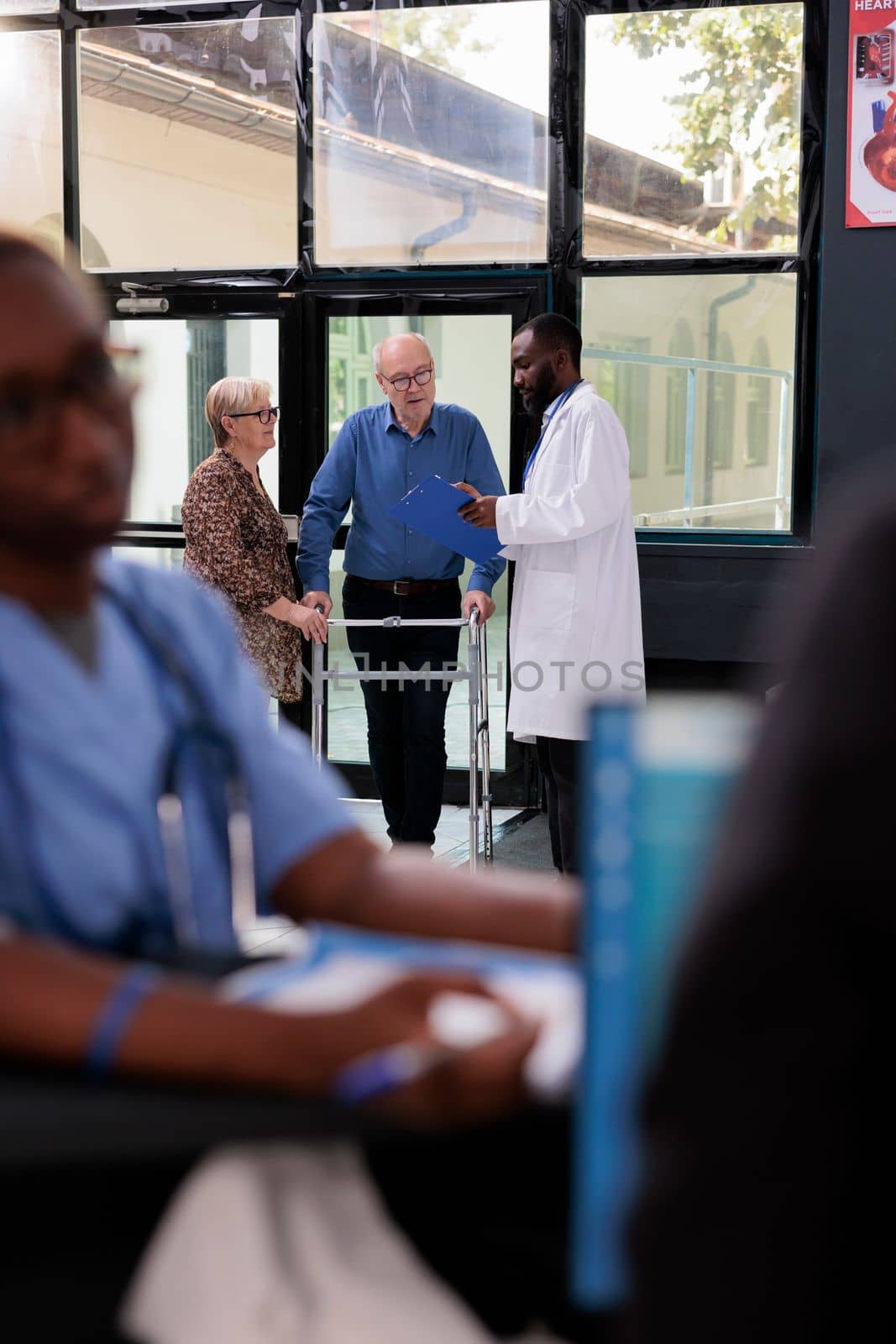 Practitioner doctor discussing illness symptoms with injured elderly patient by DCStudio