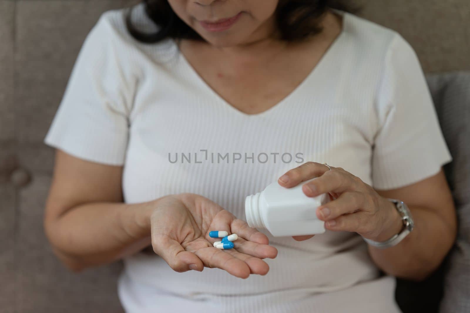 Elderly Asian Woman taking pill at home. Age, Medicine, Healthcare and People concept