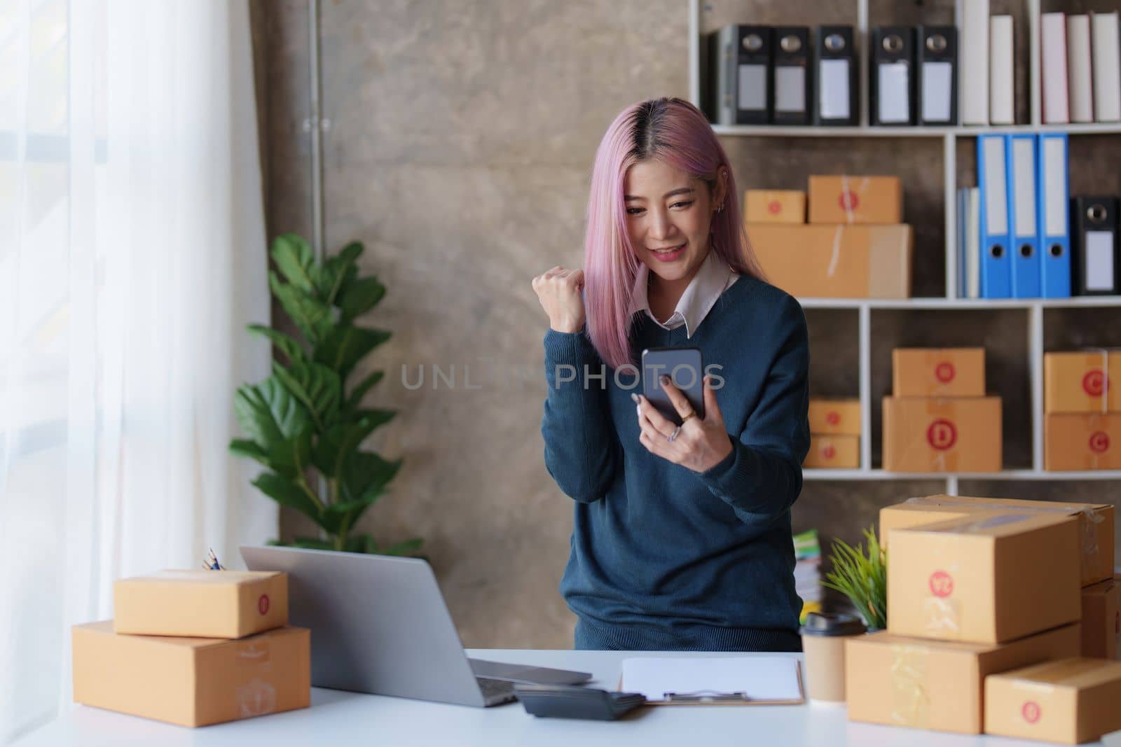 Startup small business entrepreneur of freelance Asian woman using a laptop with box Cheerful success online marketing packaging box and delivery SME idea concept by itchaznong