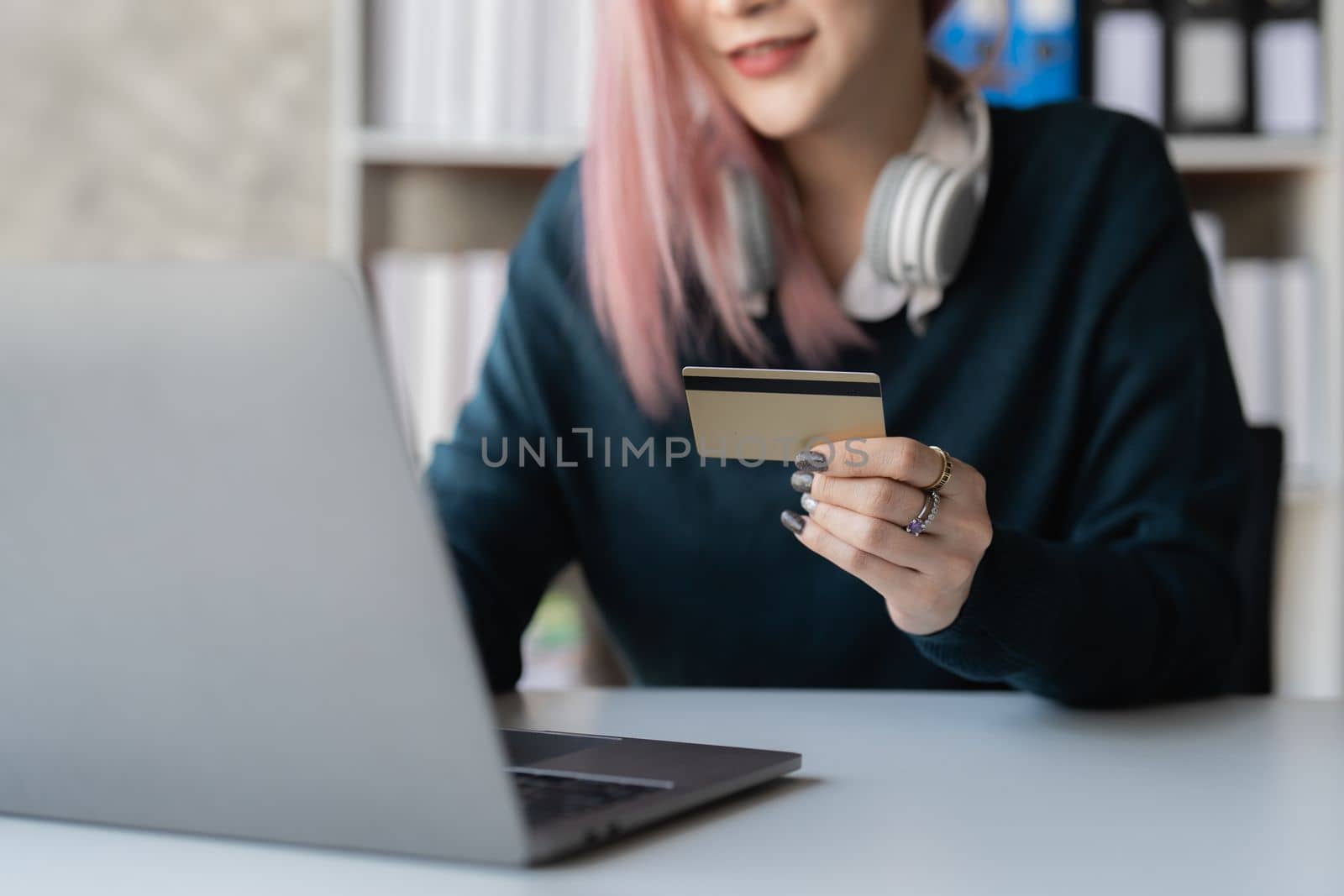 Young person using credit card and laptop computer. Online shopping, e-commerce concept by itchaznong