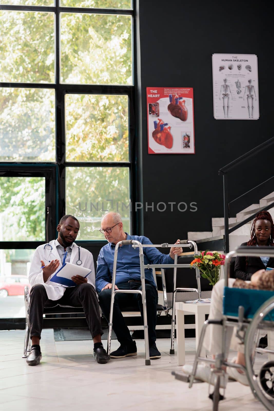 African american doctor holding clipboard explaining medical expertise to senior patient by DCStudio