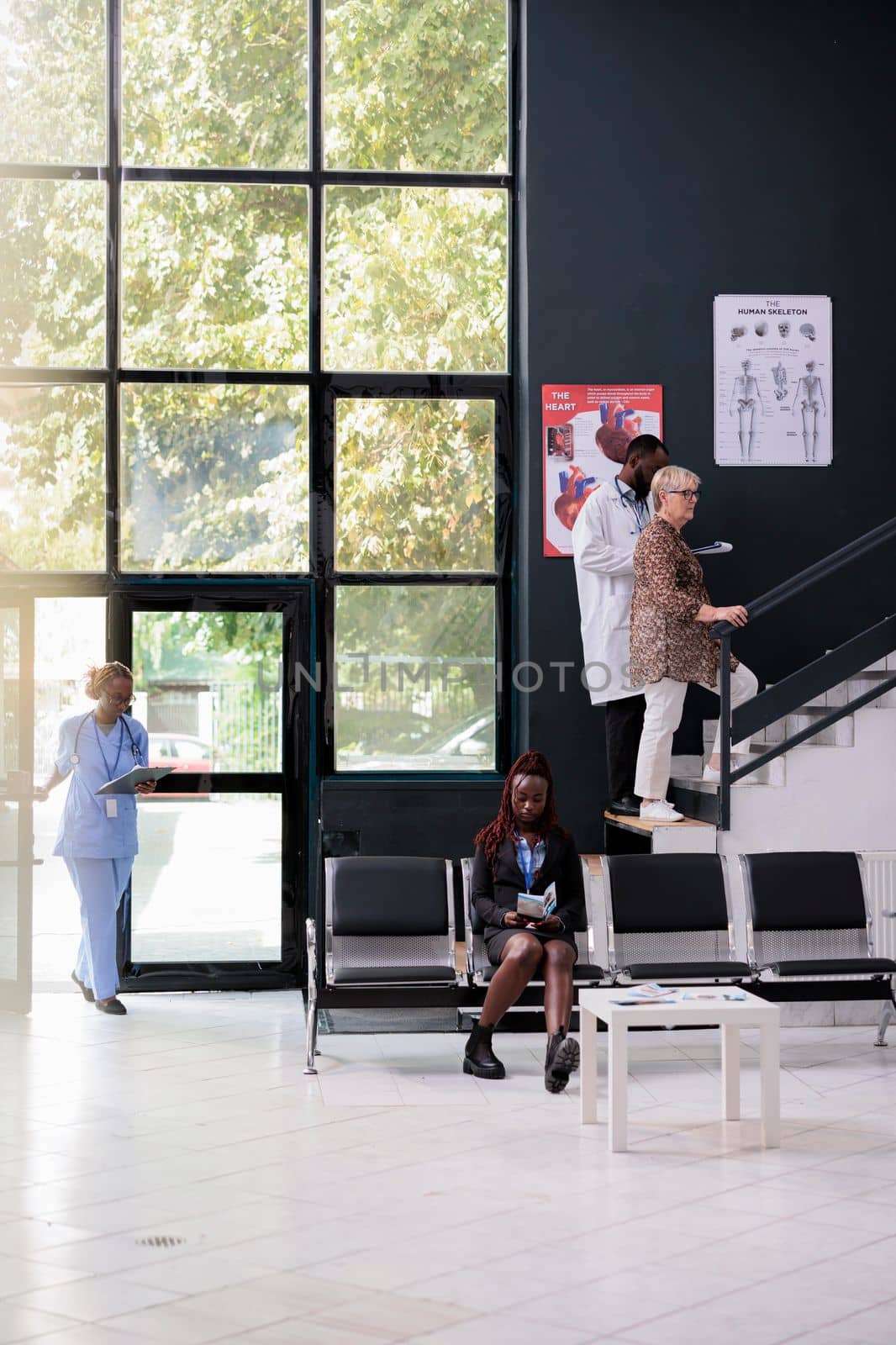 Elderly patient going to medical consultation with practitioner doctor during checkup visit in hospital waiting area. Clinical staff working at health care treatment to help cure patients disease