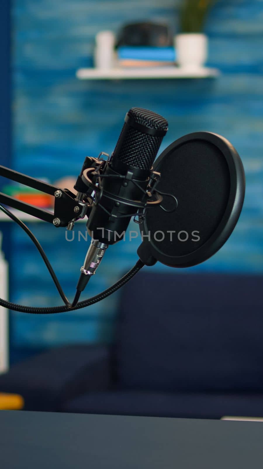 Station for recording and speaking during podcast in night in empty livin room studio. Influencer recording social media content with production microphone, digital web internet streaming station