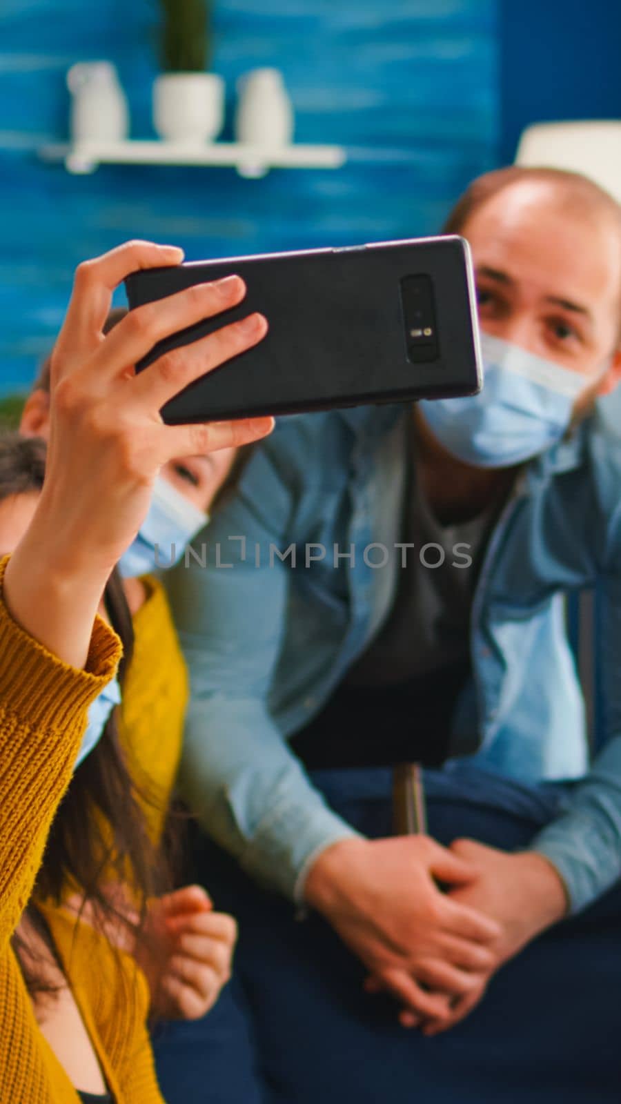 Friends from diverse cultures and races taking selfie wearing masks by DCStudio