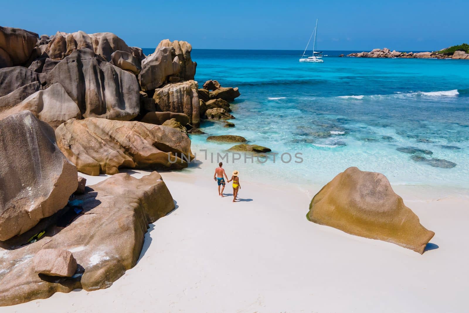 Anse Cocos beach, La Digue Island, Seychelles, Drone aerial view of La Digue Seychelles bird eye view.of tropical Island, couple men and woman walking at the beach during sunset at a luxury vacation