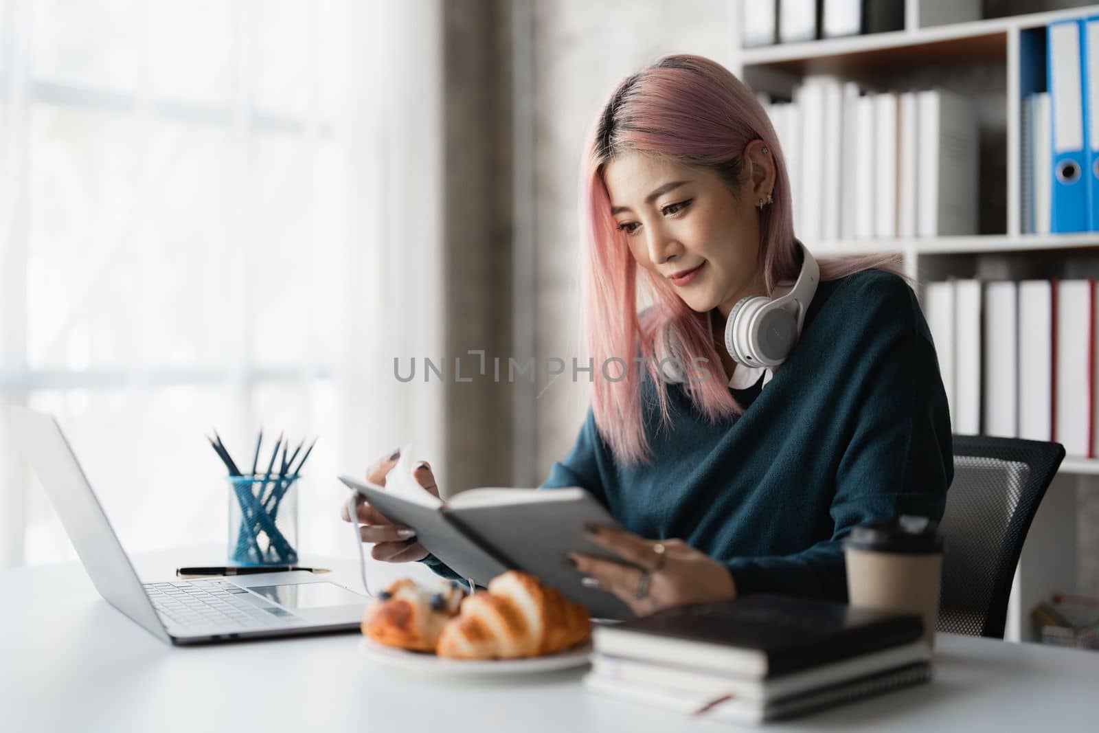 Portrait of asian beautiful young woman reading a book at home.