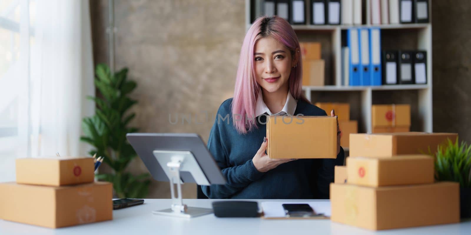 Startup small business entrepreneur of freelance Asian woman using a laptop with box Cheerful success online marketing packaging box and delivery SME idea concept.