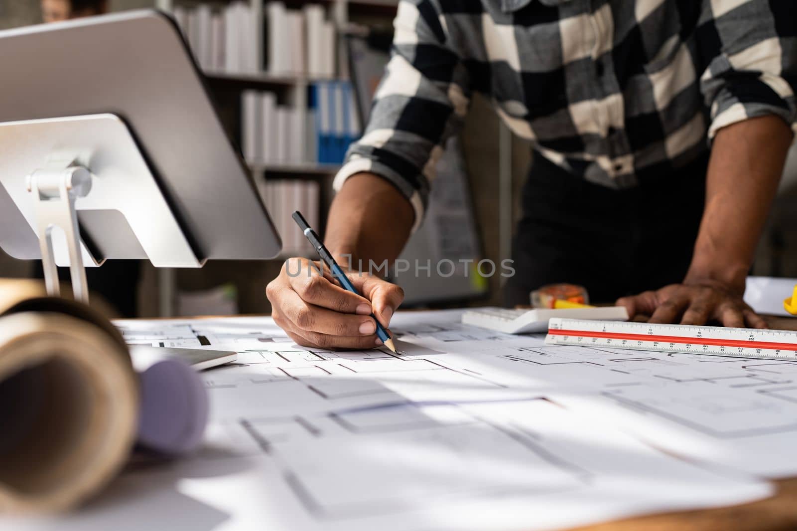 Architect man working with blueprints for architectural plan, engineer sketching a construction project, green energy concept.