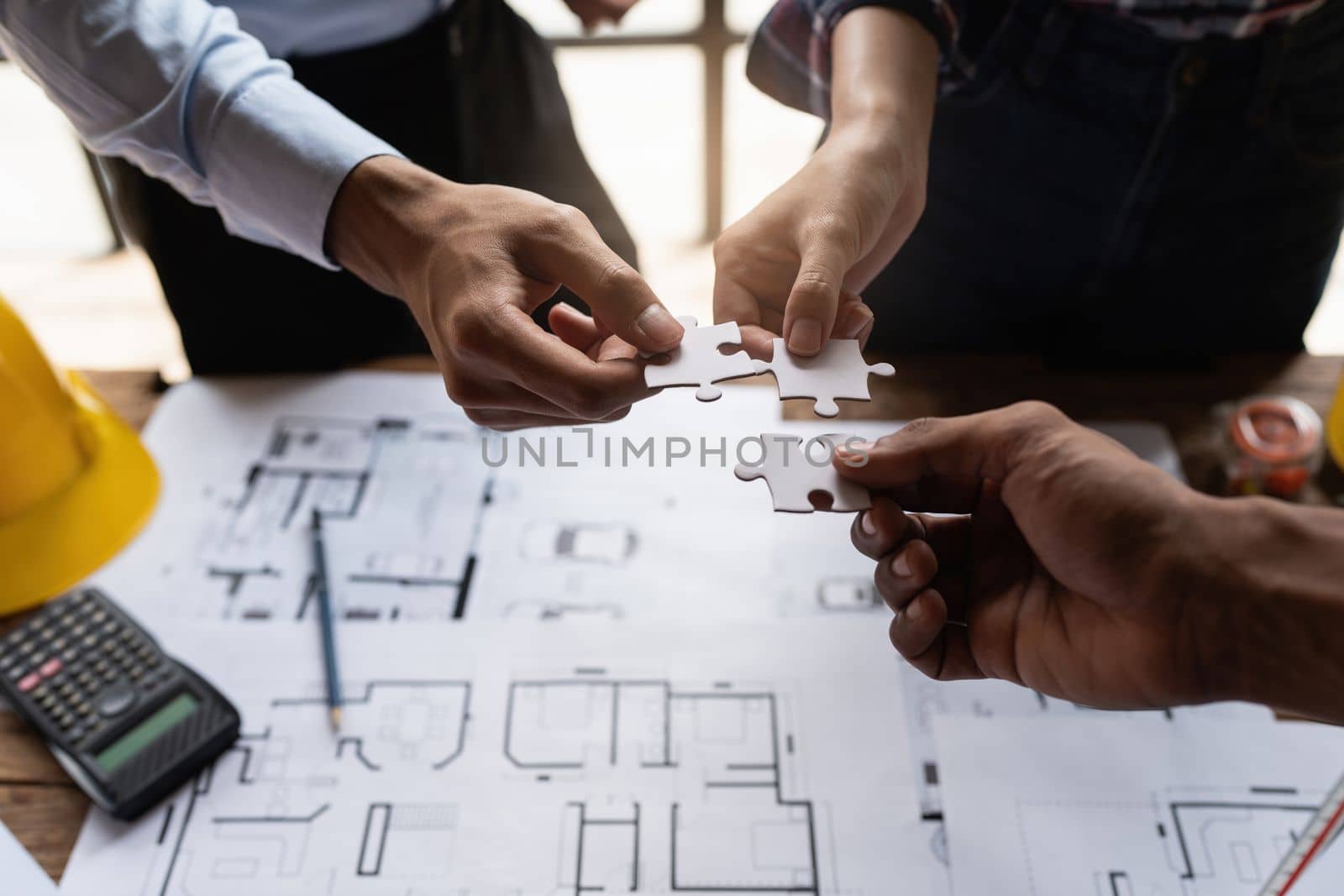 Architect team working with blueprints for architectural plan, engineer sketching a construction project, green energy concept by itchaznong