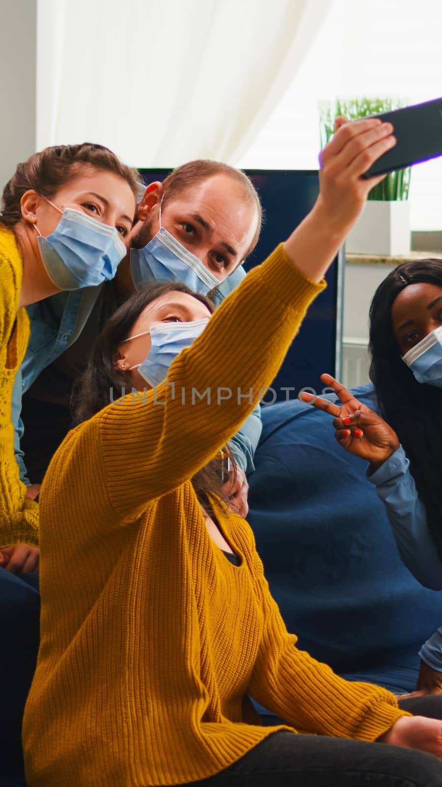 Multiracial friends taking selfie with face masks during covid 19 outbreak by DCStudio