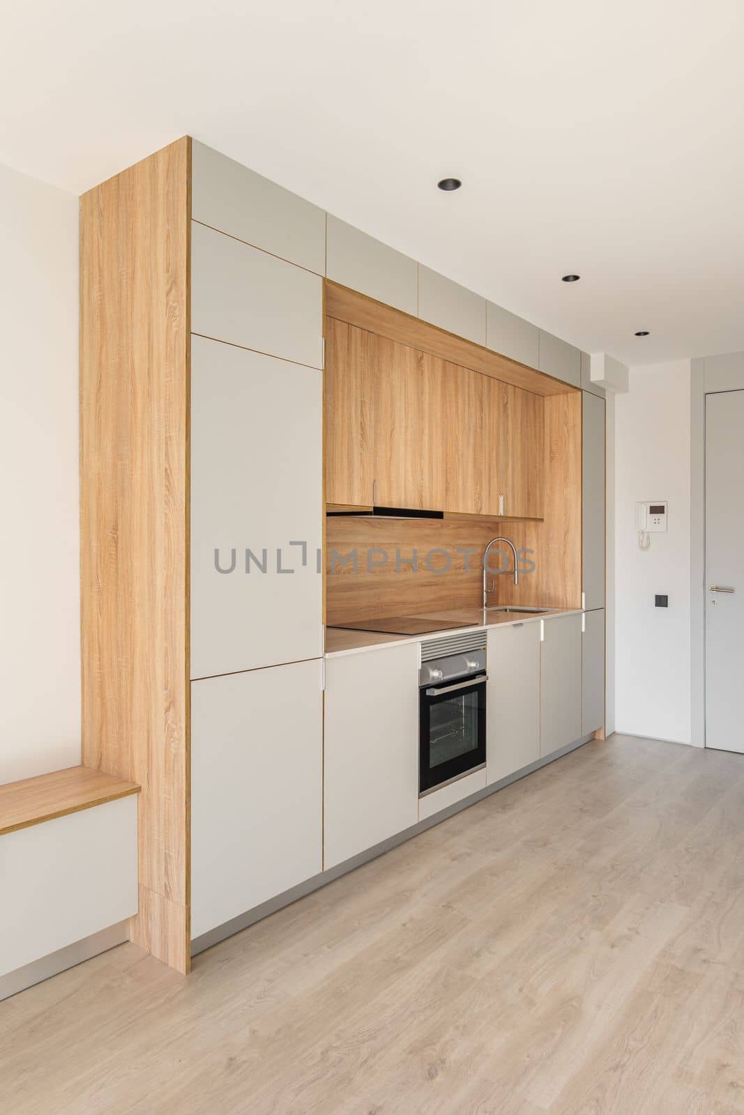 Contemporary minimal kitchen at empty refurbished apartment. Wooden furniture and modern appliances by apavlin