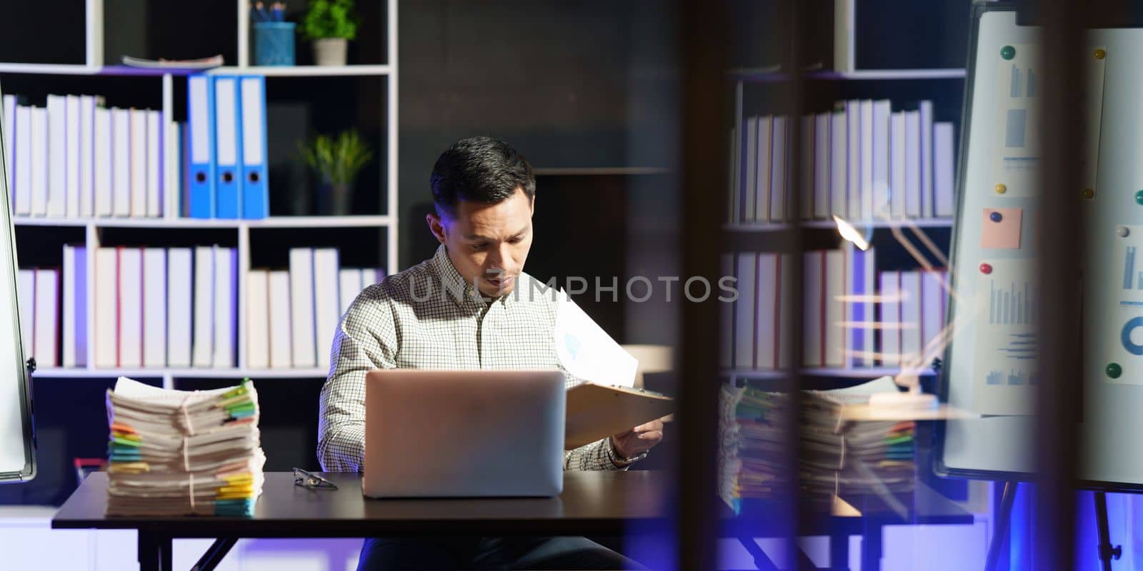 Stressed business man working over time at night. business account and finance concept.