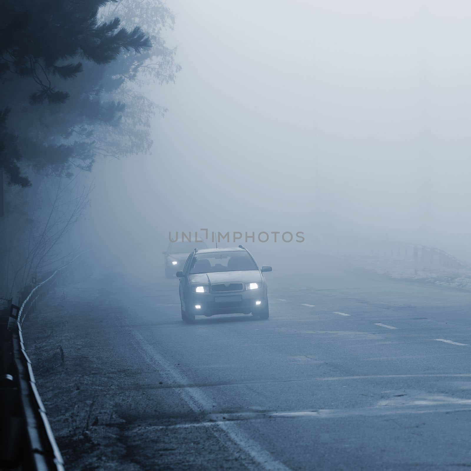 Bad weather driving - foggy hazy country road. Motorway - road traffic. Winter time.