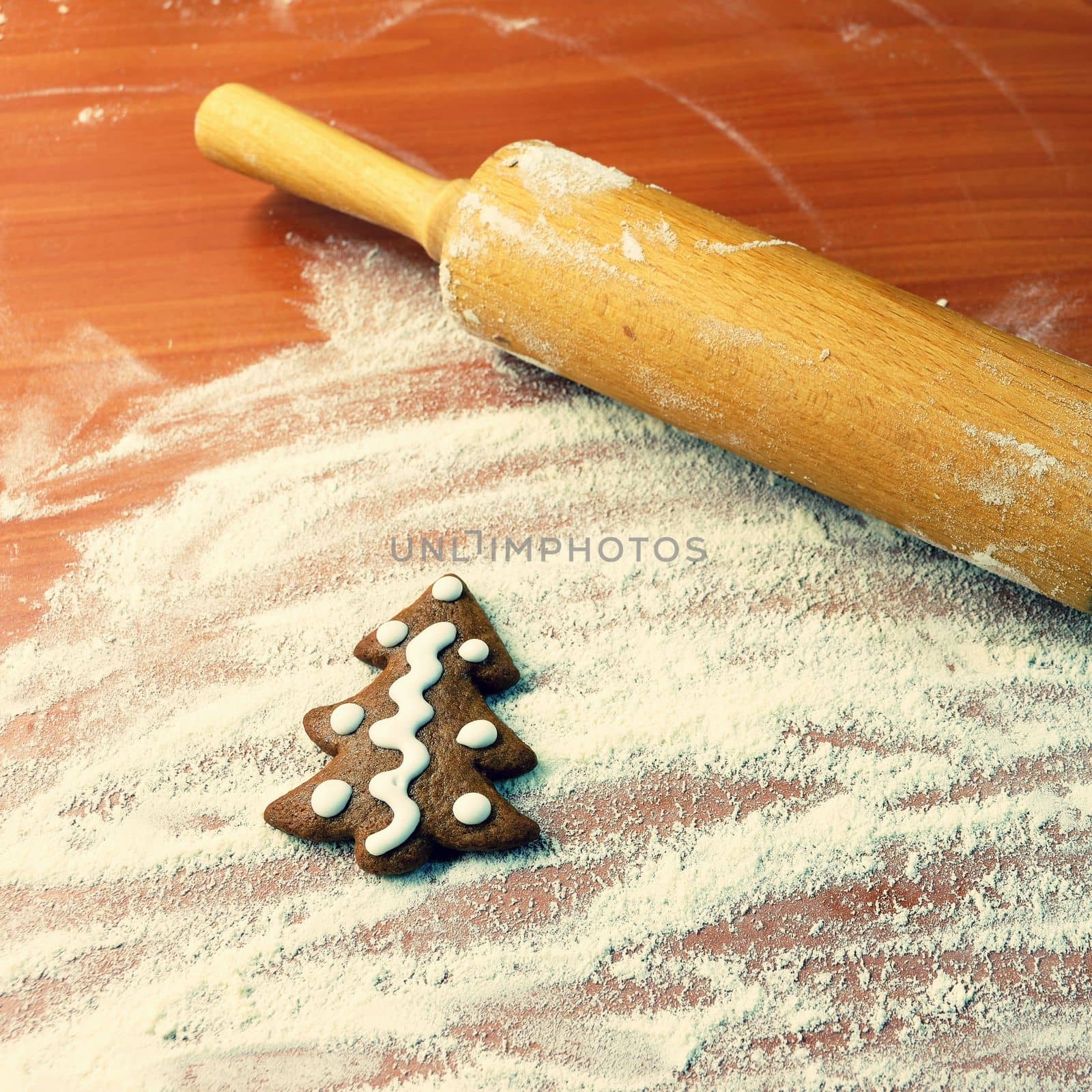 Homemade baking of Christmas cookies in the kitchen.
Gingerbread Christmas tree on table with flour and rolling pin.