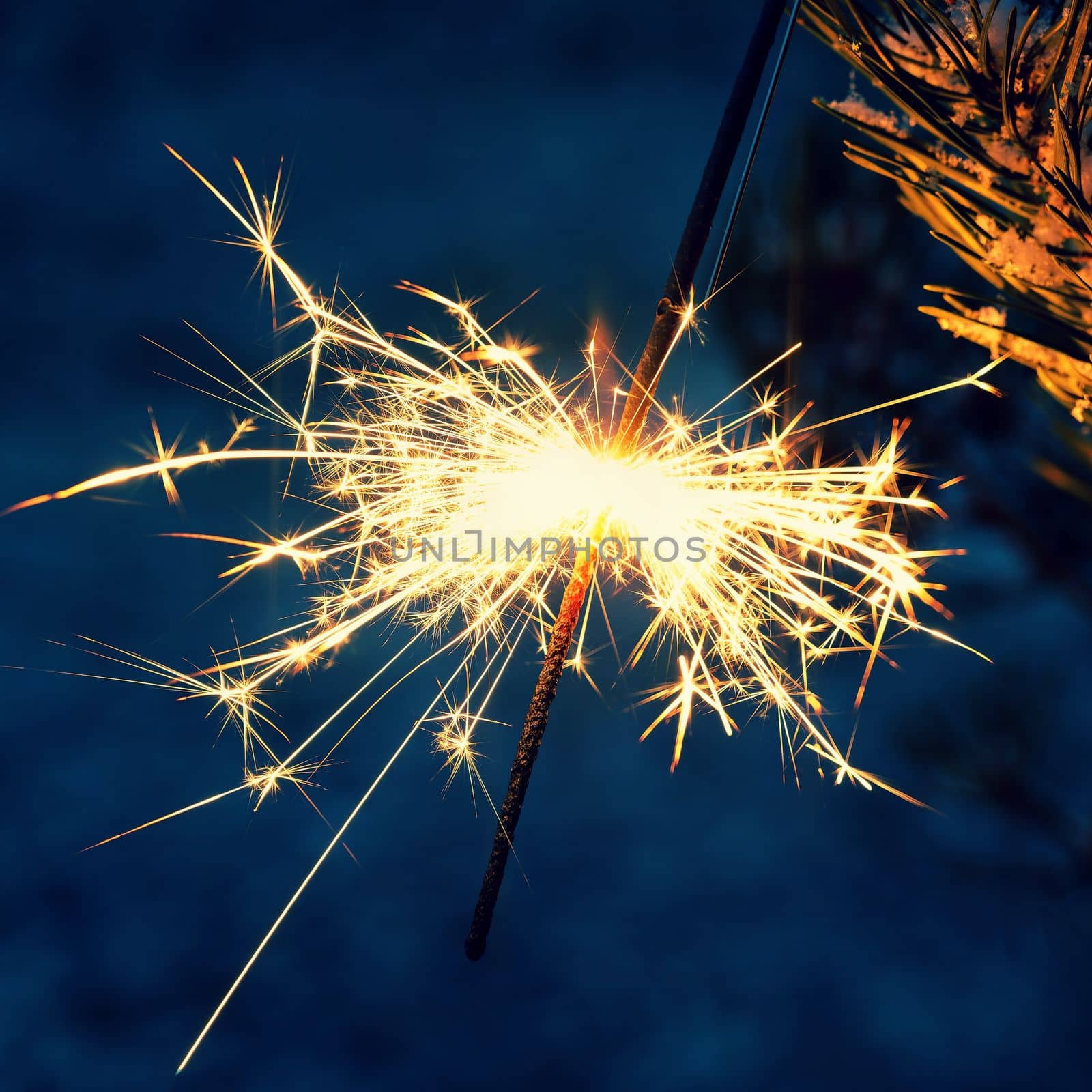 Christmas background. A sparkler on a Christmas tree in the evening outside with snow. Concept for winter season, holidays and new year 2023. by Montypeter