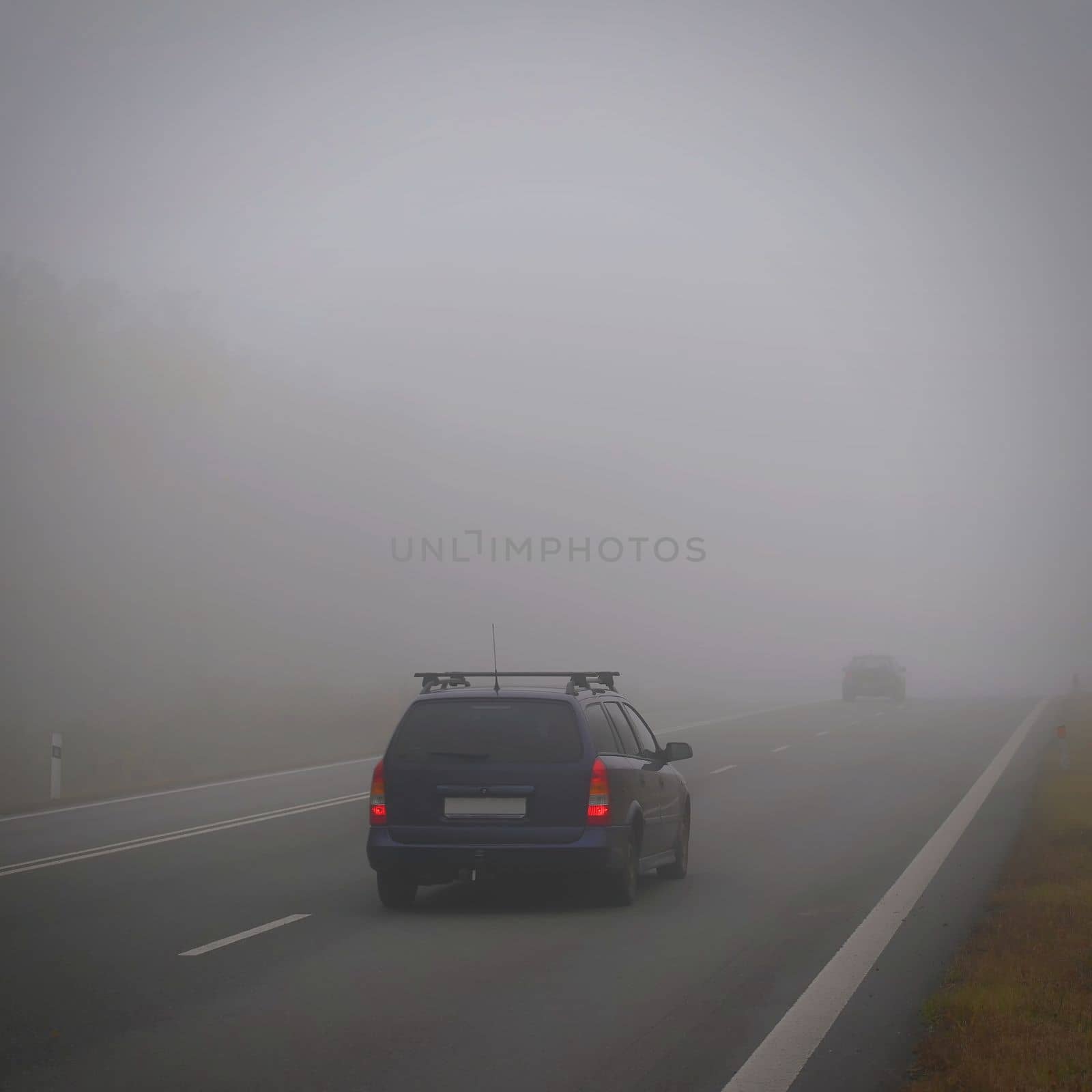 Bad weather driving - foggy hazy country road. Motorway - road traffic. Winter time. Autumn - fall.  by Montypeter