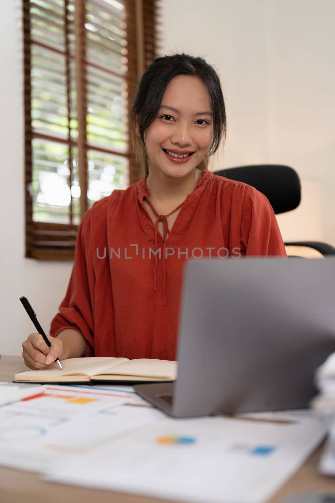 Asian Business woman writing saving account balance with working at home, account and saving concept.