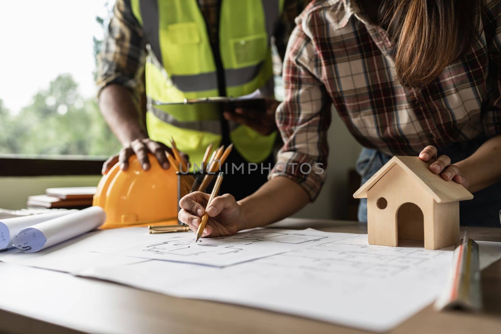 Architect man working with blueprints for architectural plan, engineer sketching a construction project concept by itchaznong