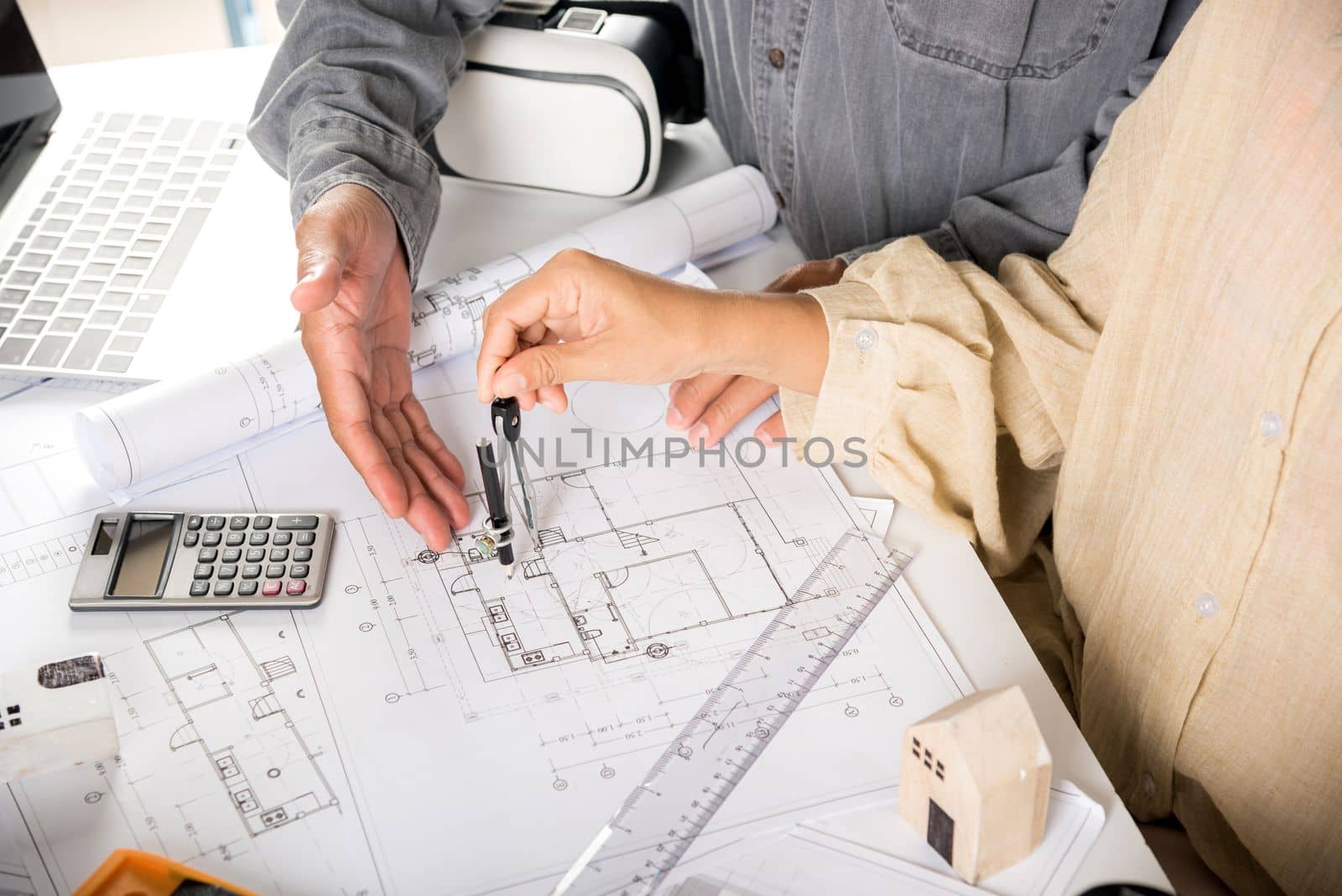 Two engineers pointing at drawings project, Architect team meeting consult and work for architectural construction project working with partner and engineering after editing on blueprint paper plans