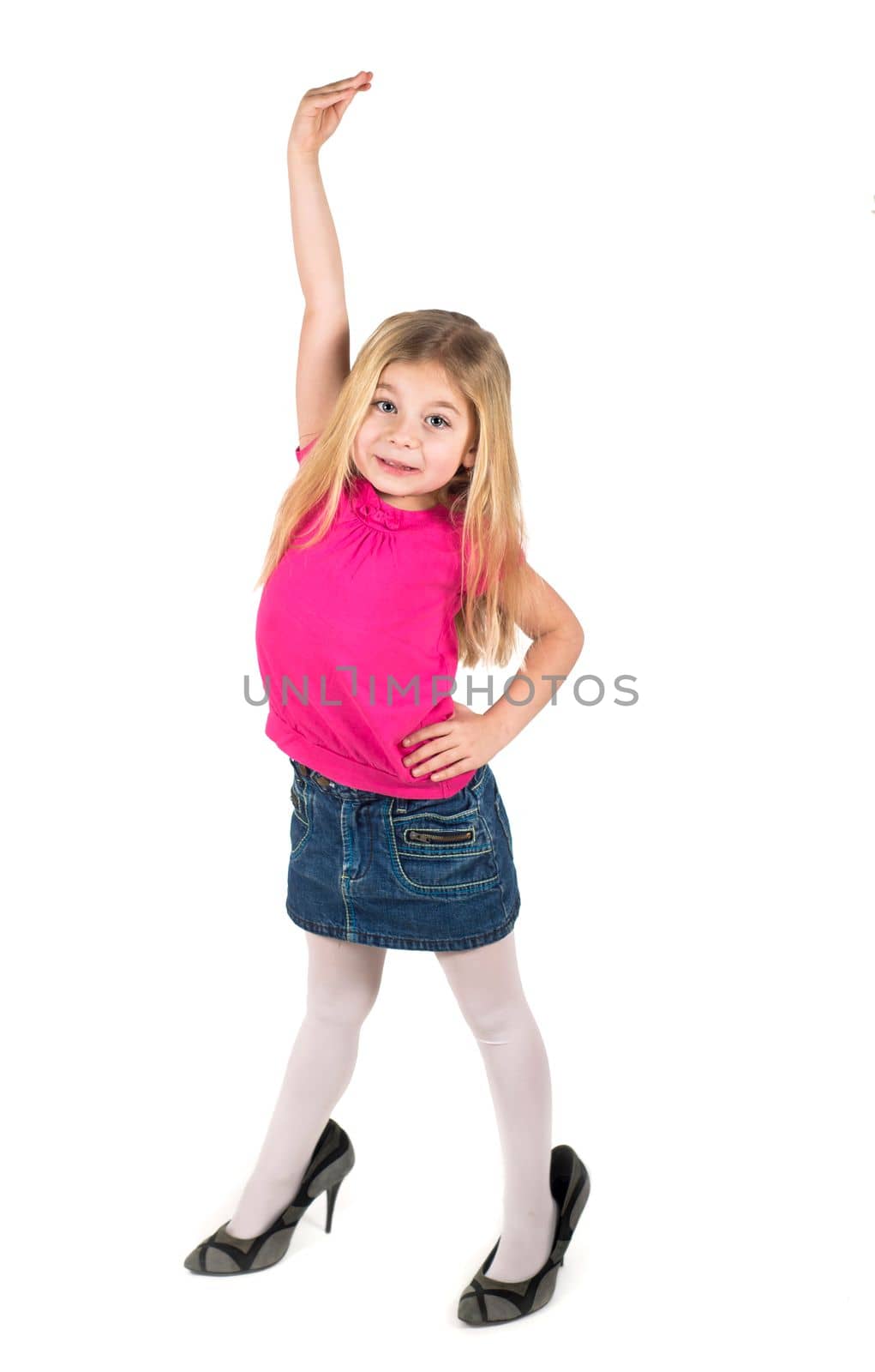 Little girl wearing big high-heeled mother's shoes isolated on white background