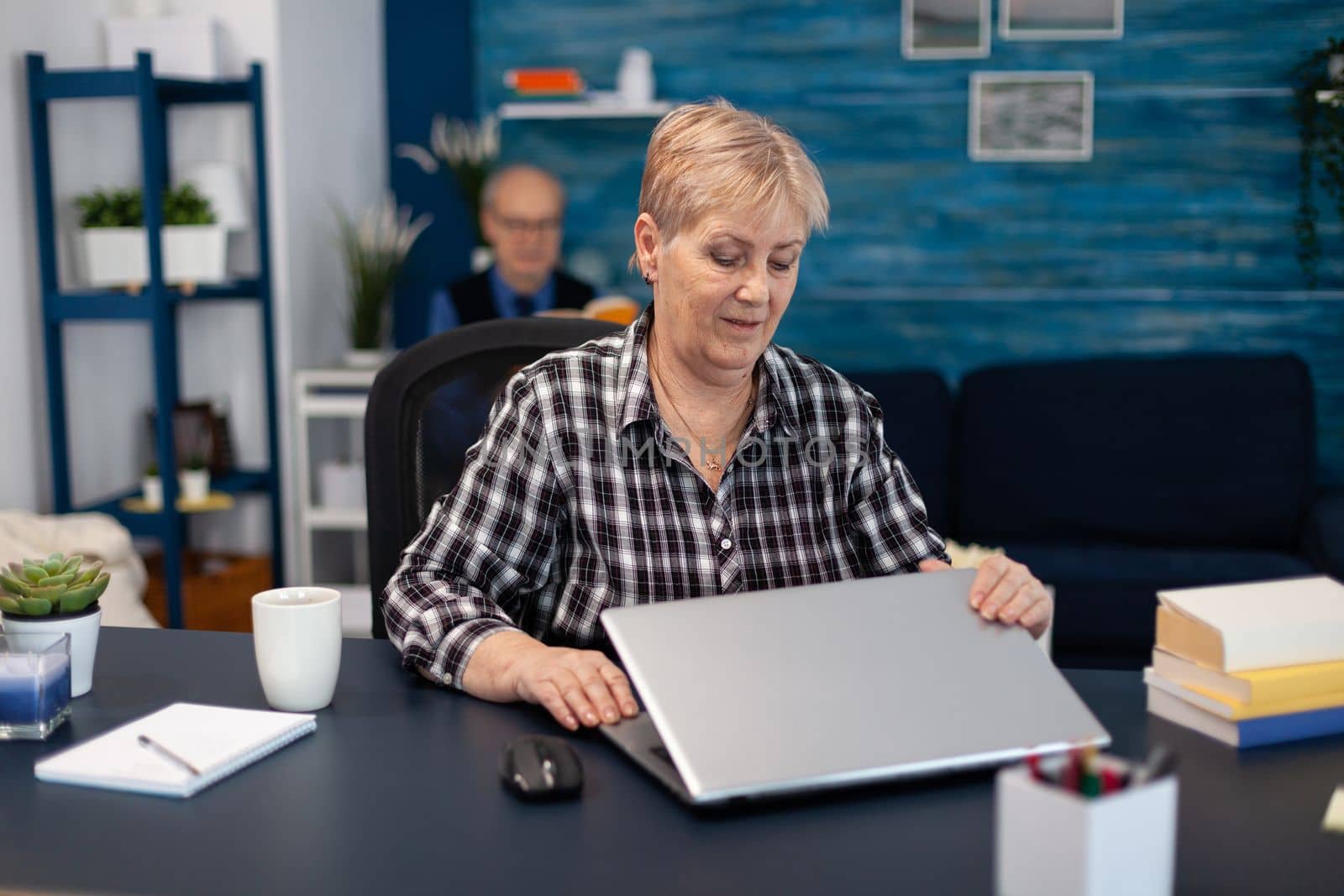 Mature entrepreneur sitting in front of portable computer by DCStudio