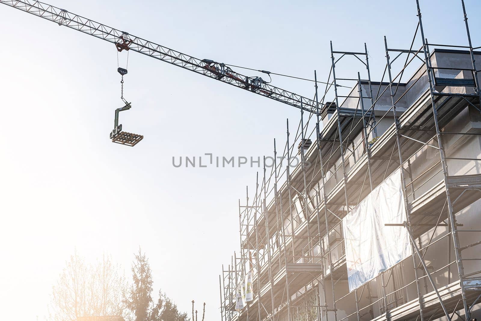 Construction and decoration of scaffolds of the building. Tower crane.