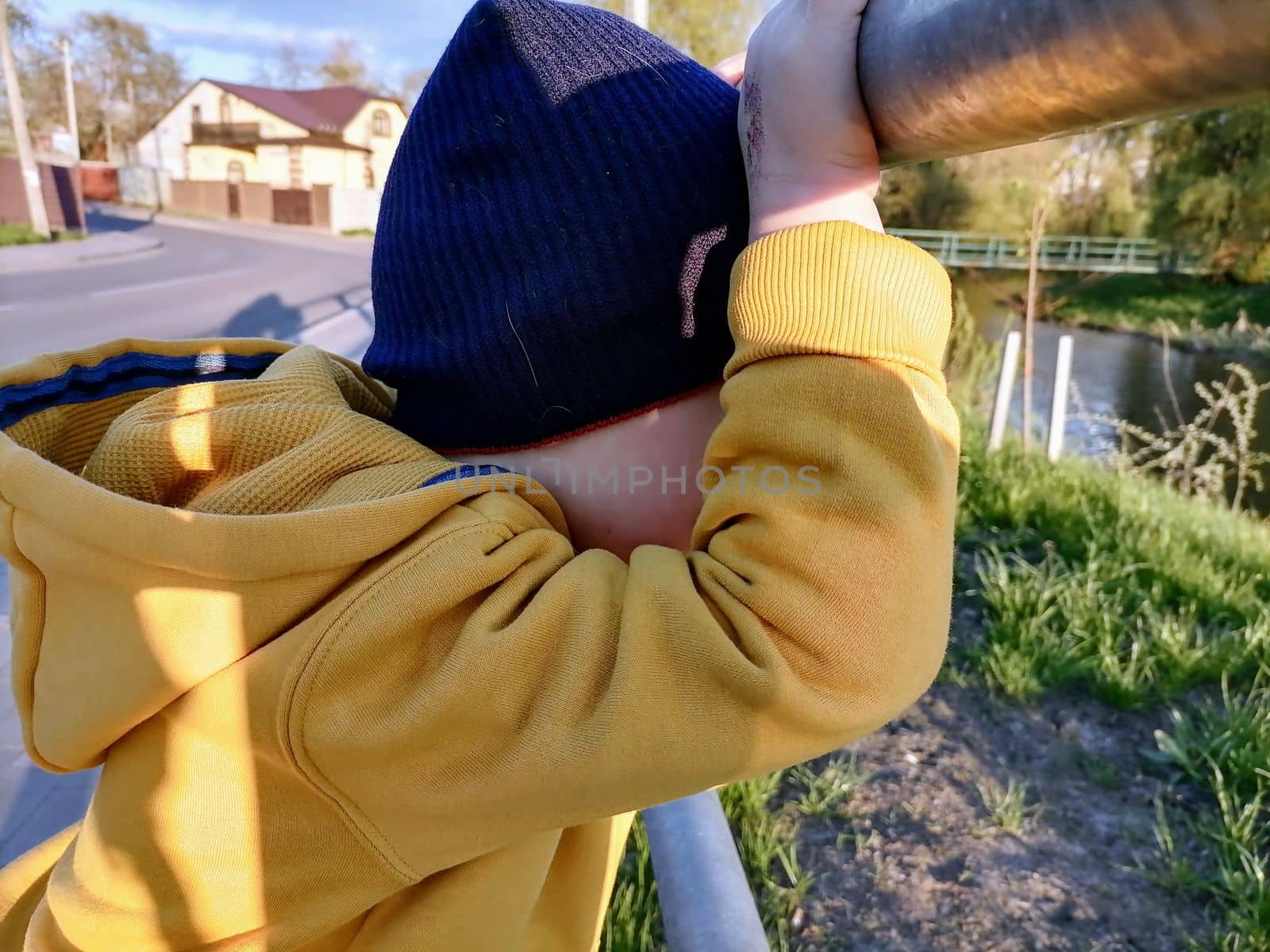 Adorable little toddler boy having fun on playground, child wearing yellow hoody jacket. High quality photo