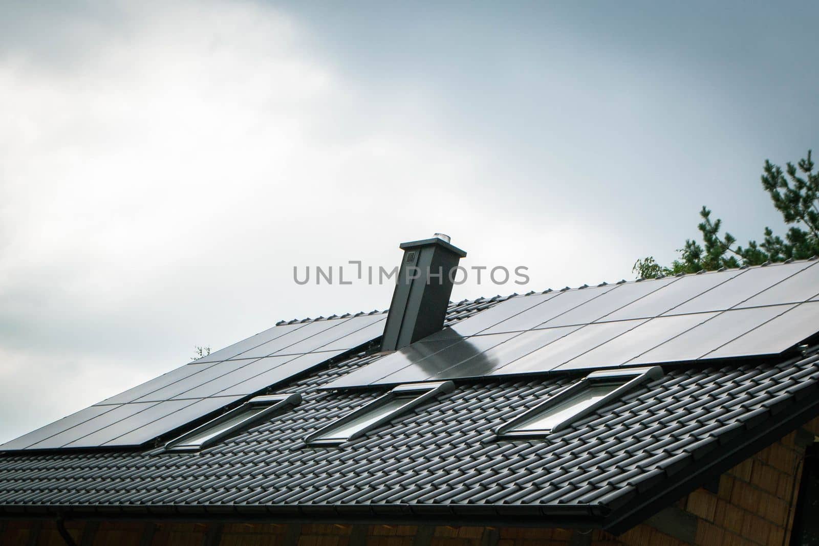 House roof with photovoltaic modules. Historic farm house with modern solar panels on roof and wall High quality photo