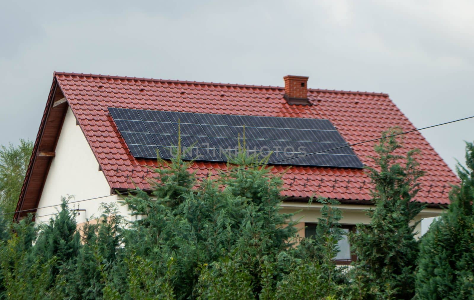 House roof with photovoltaic modules. Historic farm house with modern solar panels on roof and wall High quality photo