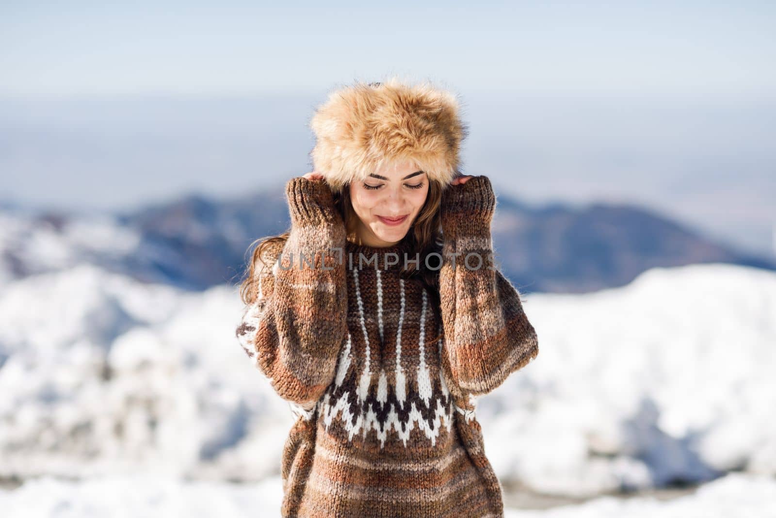 Funny woman enjoying the snowy mountains in winter, in Sierra Nevada, Granada, Spain. Female wearing winter clothes.