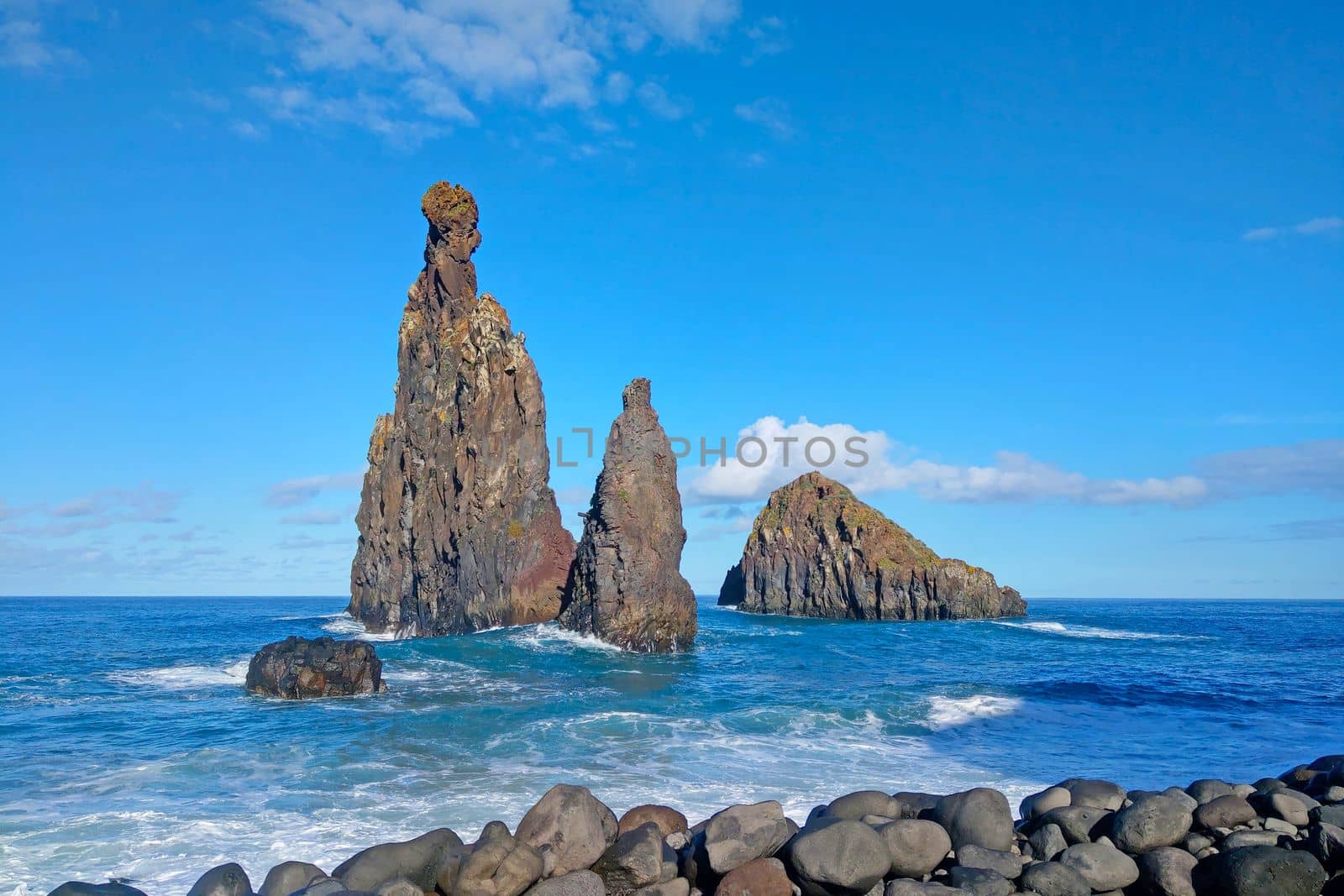 The waves of the ocean wash the rocks in the water. The background of nature