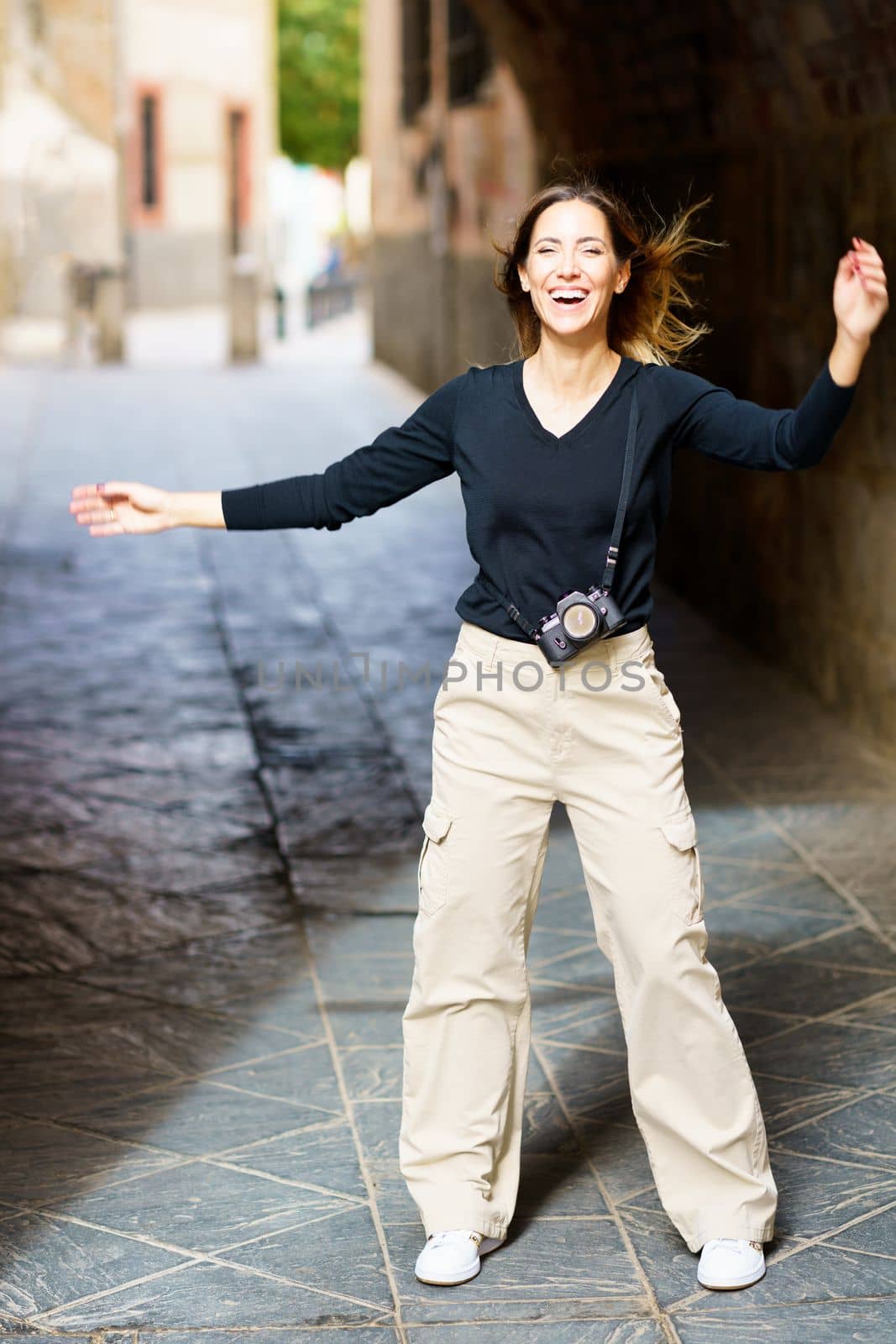 Delighted woman laughing on old street during holiday by javiindy