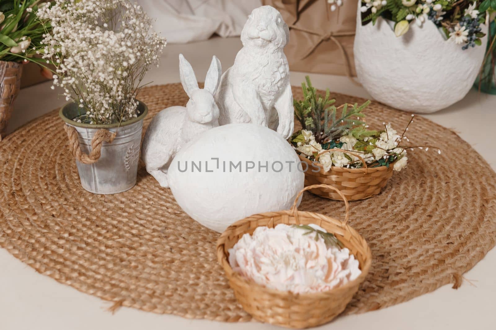 Interior floral Easter composition. Figurines of Easter bunnies and a large eggshell. The concept of home decoration for the Happy Easter holiday