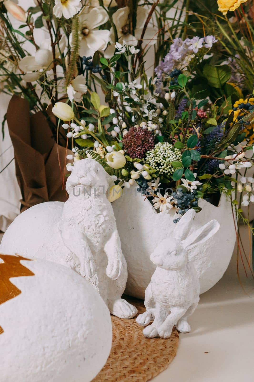 Interior floral Easter composition. Figurines of Easter bunnies and a large eggshell. The concept of home decoration for the Happy Easter holiday