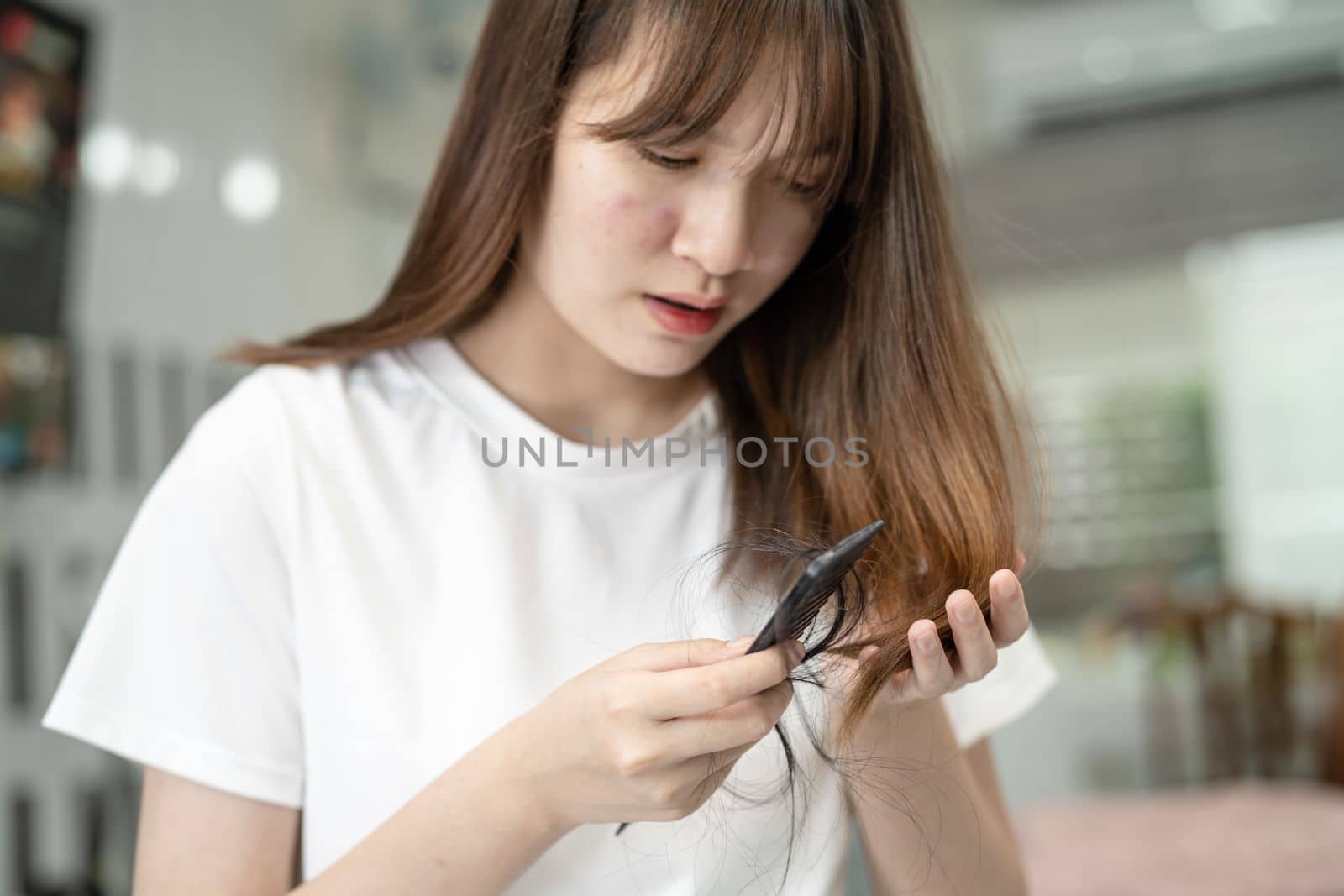 Asian woman have problem with long hair loss attach to comb brush.