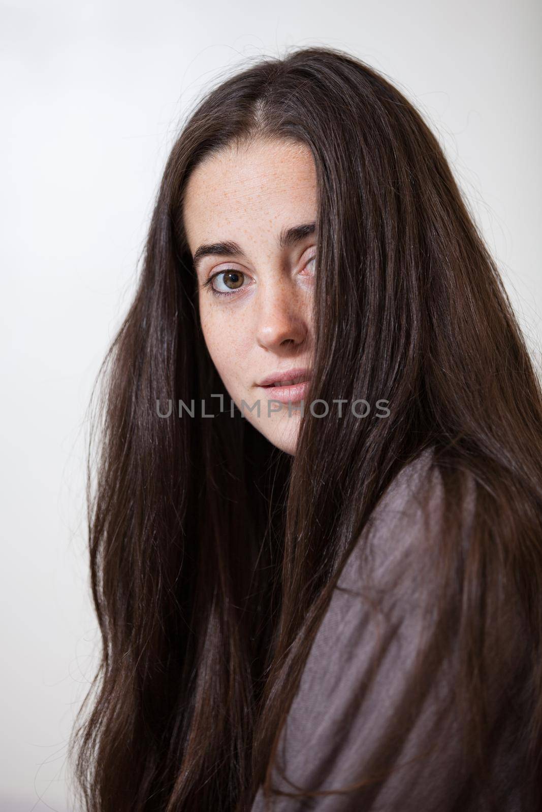 Portrait of a young and sweet natural woman without makeup with long brown hair by jp_chretien