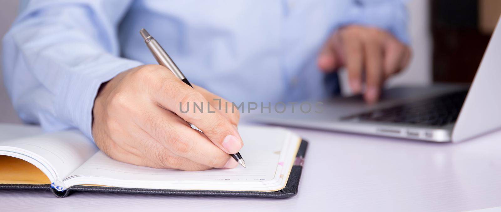 Hand of man watching webinar on laptop computer and writing on notebook for learning, education with e-learning online, video conference and training, seminar course, knowledge and study with digital.