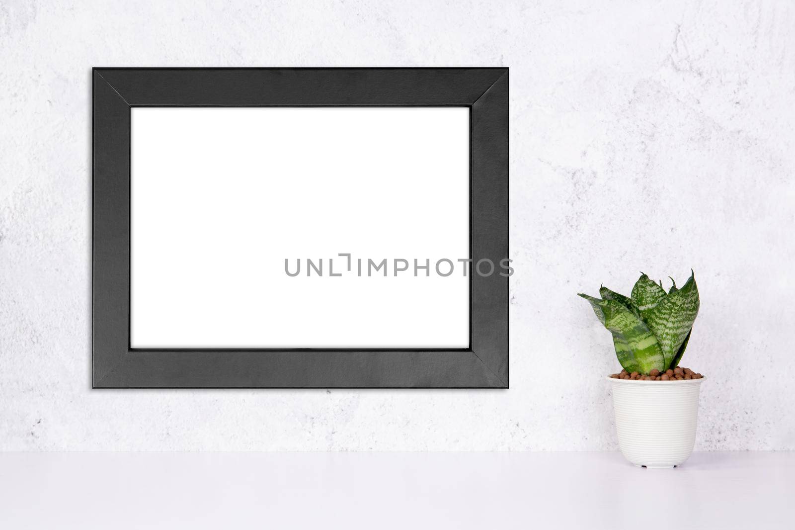 Mockup black frame horizontal on the wall and plants in pot on table top at home, mock up poster for presentation on desk, your design for gallery photo and picture, border template for advertising.