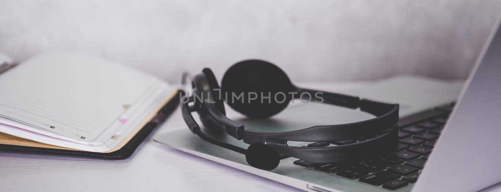 Laptop computer and headphone on desk, e-learning online, webinar for education and learning, seminar with notebook, video conference, headset for multimedia, course and classroom to internet. by nnudoo