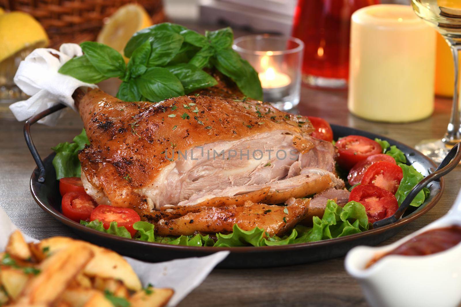 Sliced baked turkey drumstick on a vegetable tray at the Thanksgiving dinner table