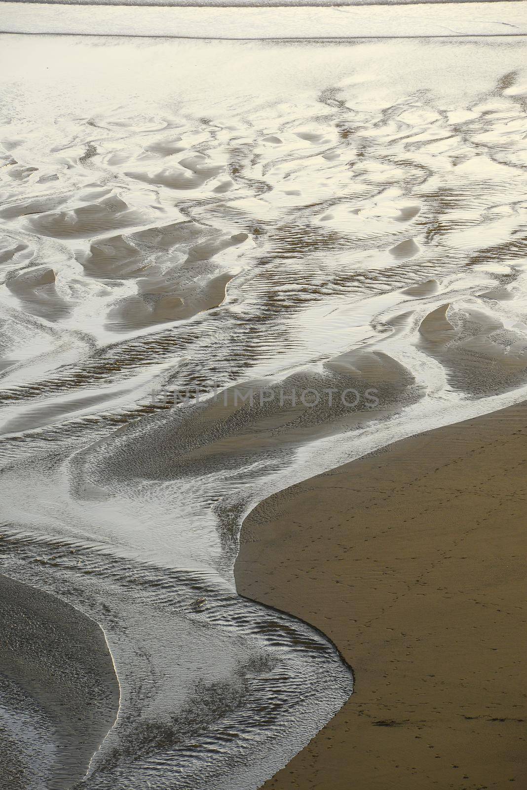 sand pattern from a creek flowing on a beach