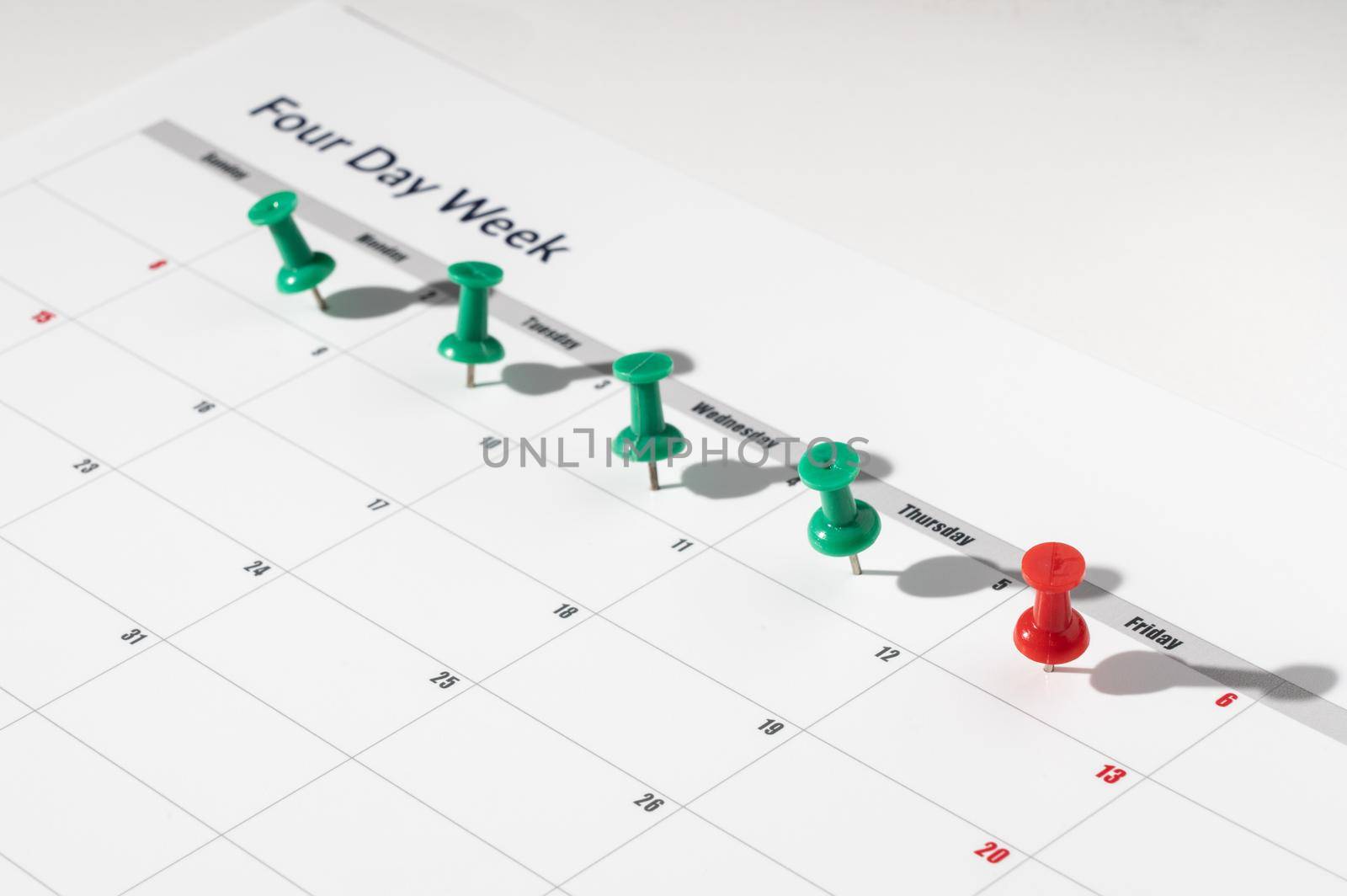 Printed calendar for a 4 day working week showing weekend days in red in new approach to productivity