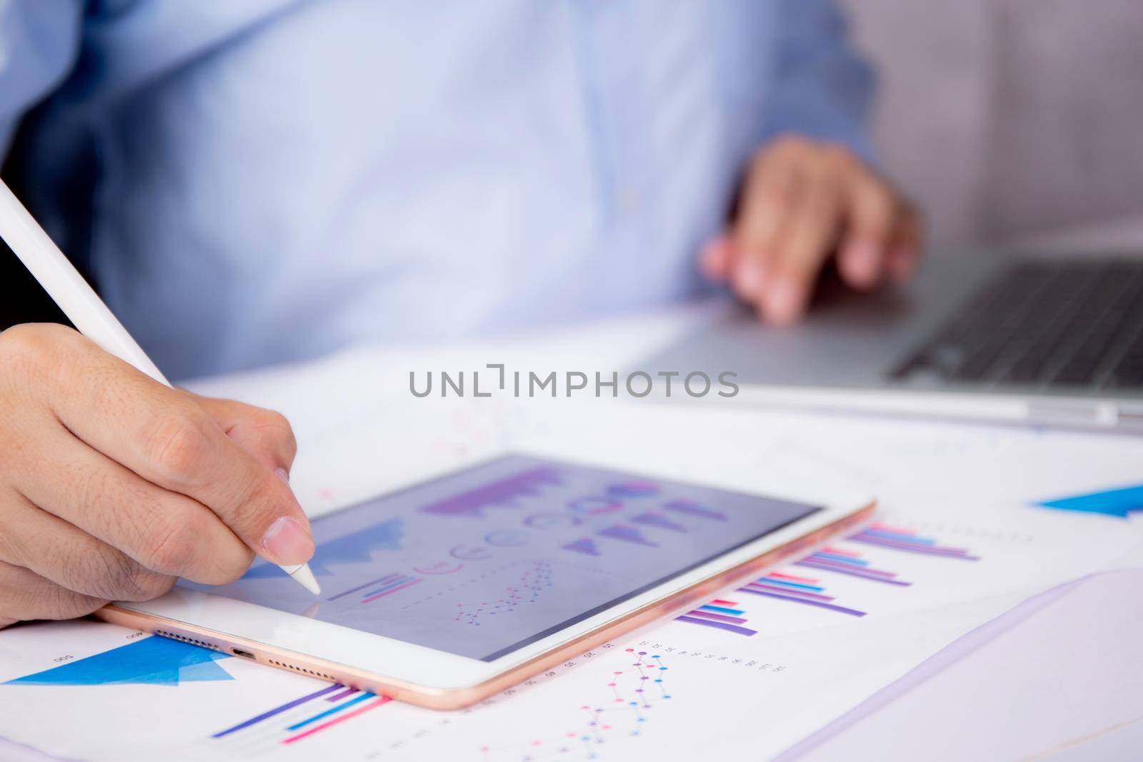Businessman planning about graph and chart of investment with report for finance on tablet computer on desk, statistic for financial and profit with document, digital marketing, business concept.