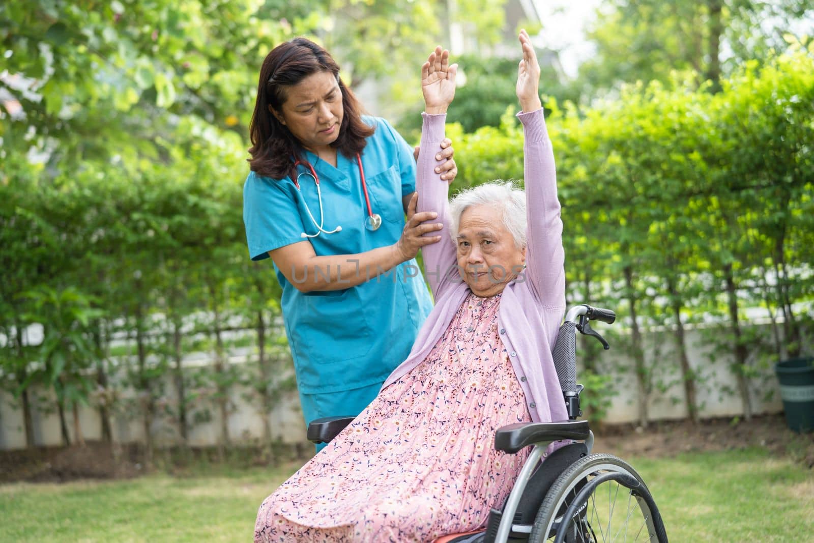 Doctor help Asian senior or elderly old lady woman patient exercise on wheelchair with happy in park.