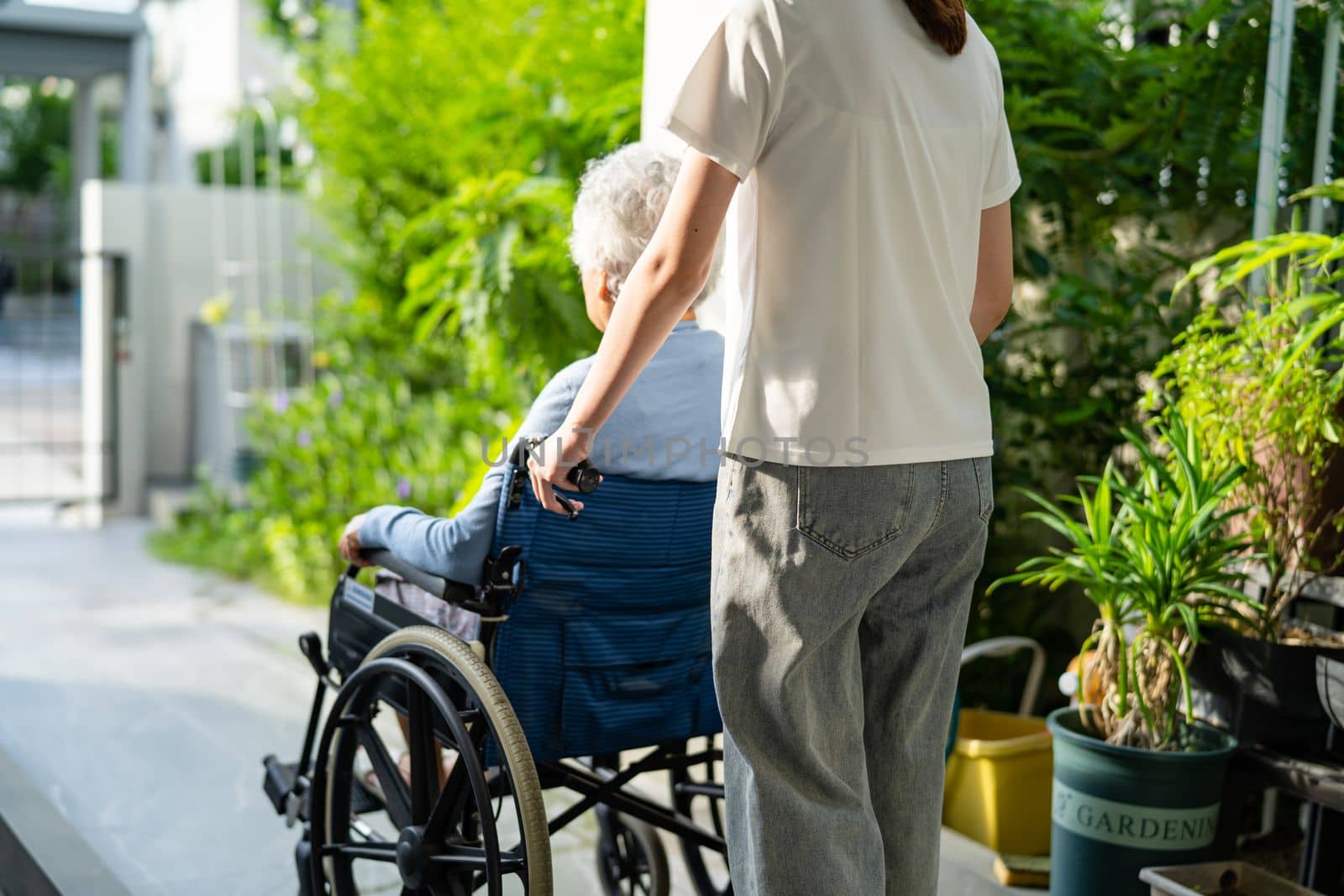 Caregiver help and care Asian senior or elderly old lady woman patient sitting on wheelchair to ramp in nursing hospital, healthy strong medical concept. by pamai