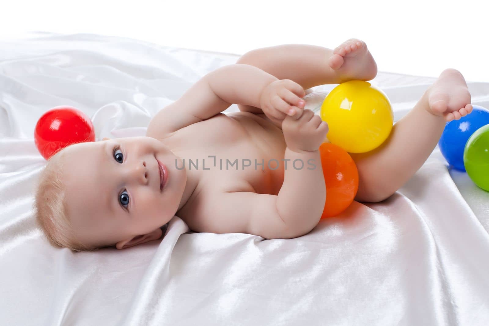 Portrait of happy baby with colored balls. Isolated on white